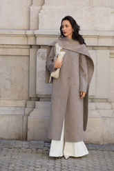 a lady in a grey long alpaca coat and a pair of white wide leg pants